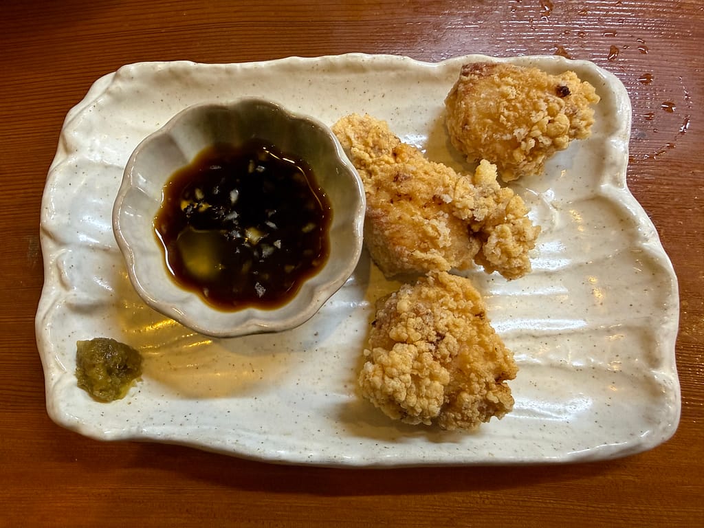 三代目らーめん処 まるは 極 船橋店の唐揚げ(小)。揚げたての唐揚げにタレと柚子胡椒が添えられた一皿。