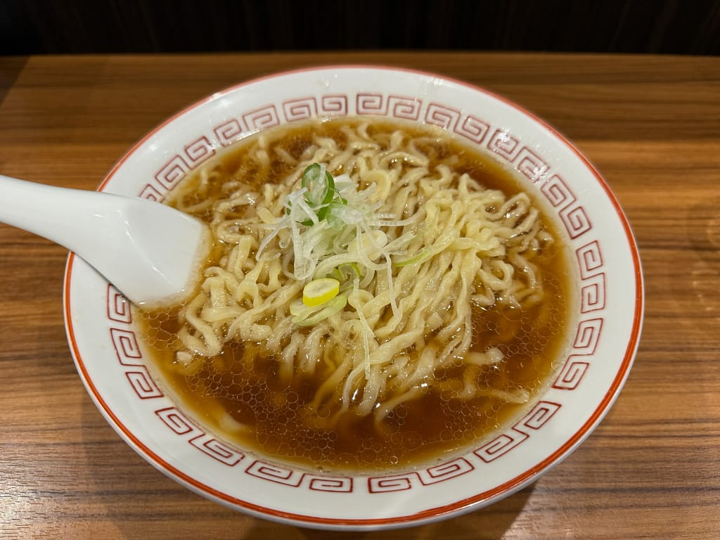 喜多方食堂 山海のかけらーめん(朱)。濃口醤油の澄んだスープに平打ちちぢれ麺とネギをのせたシンプルな一杯