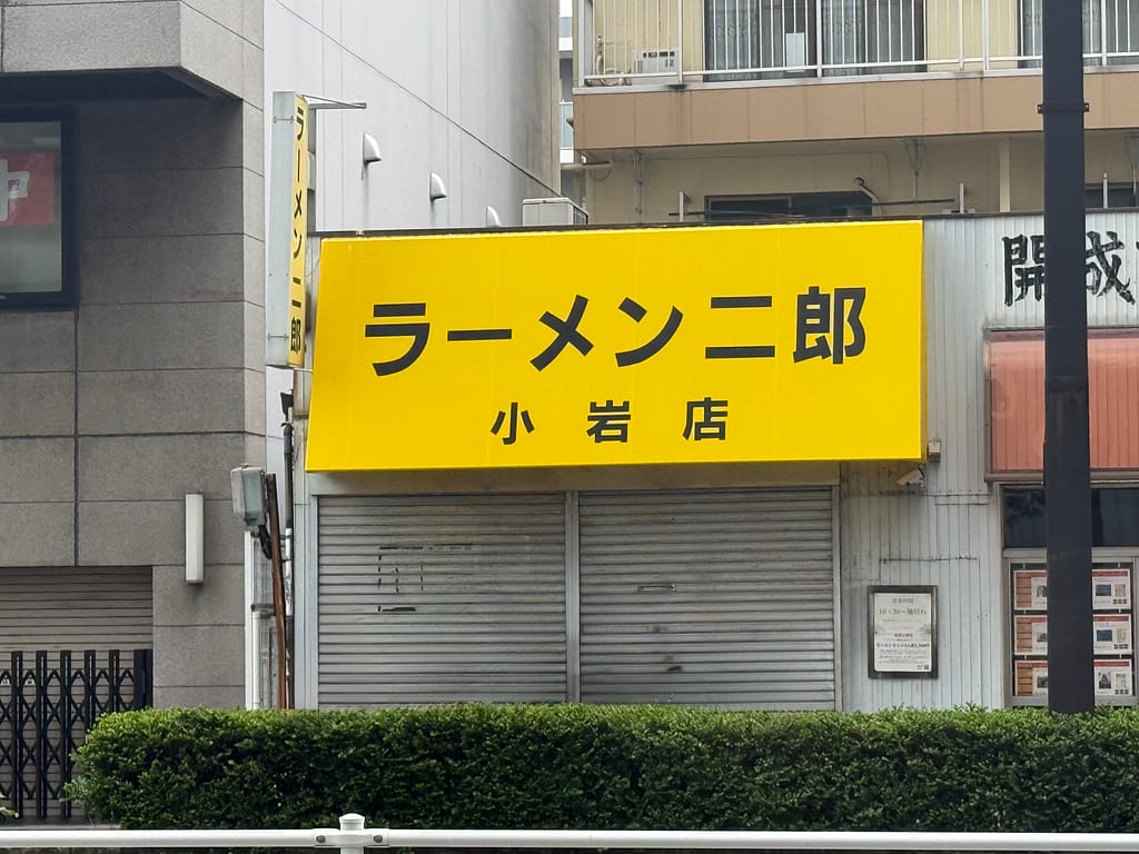 ラーメン二郎 小岩店の店舗外観。黄色い看板に「ラーメン二郎 小岩店」と書かれている。
