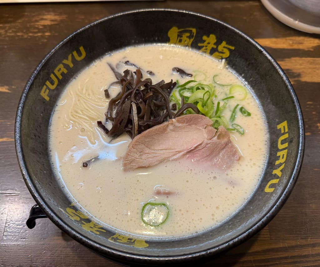 博多風龍 上野店のとんこつラーメン。クリーミーな豚骨スープに極細麺、チャーシュー、きくらげ、青ねぎがのった一杯。
