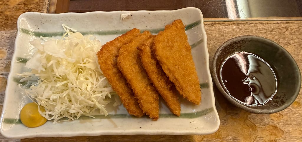 カプセルホテル&サウナ北欧のハムカツ。千切りキャベツとからし、ソースが添えられた一品。