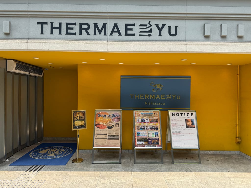 テルマー湯西麻布の店舗外観。入口前に案内看板やサウナ・スパの案内が並んでいる。
