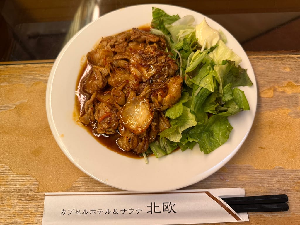 カプセルホテル&サウナ北欧(上野)の豚キムチ。甘辛い豚肉とキムチに新鮮なレタスを添えた、お酒にも合う人気メニュー。