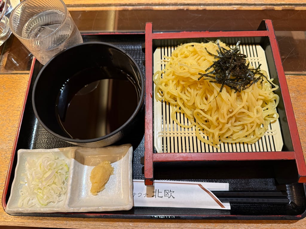 カプセルホテル&サウナ北欧のざるラーメン。冷たい麺に刻み海苔をのせ、つけ汁と薬味を添えた一品