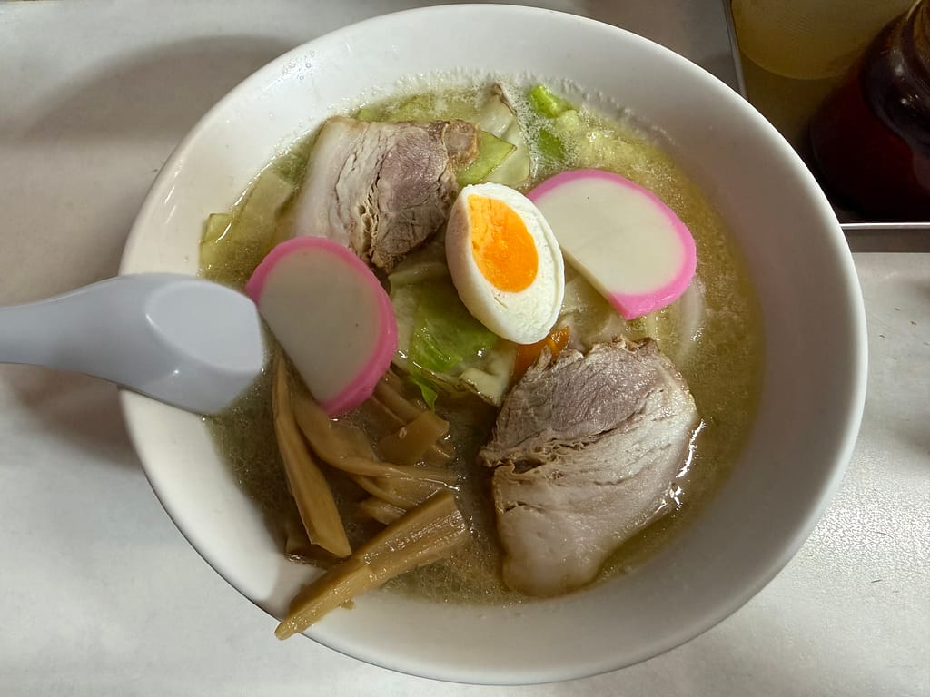 「珍々軒の五目麺。チャーシュー、ゆで卵、かまぼこ、メンマ、野菜が乗った旨味たっぷりの塩スープのラーメン」