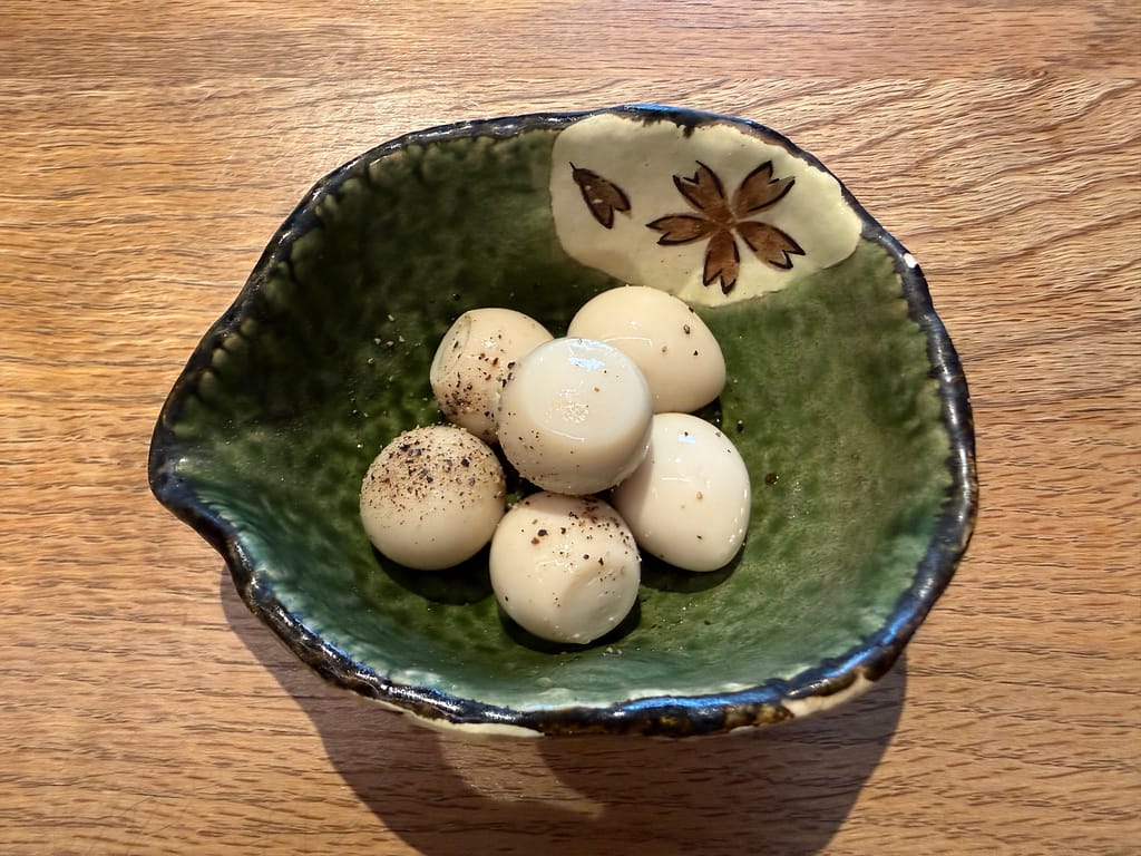 かるまる池袋のうずらのピクルス。黒こしょうがかかったうずらの卵の人気サイドメニュー。