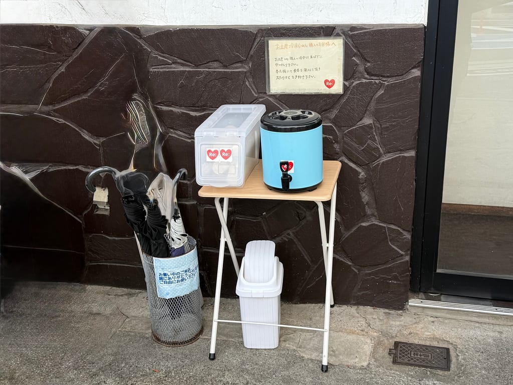 とものもとの店頭に設置された日傘と水のサービス
