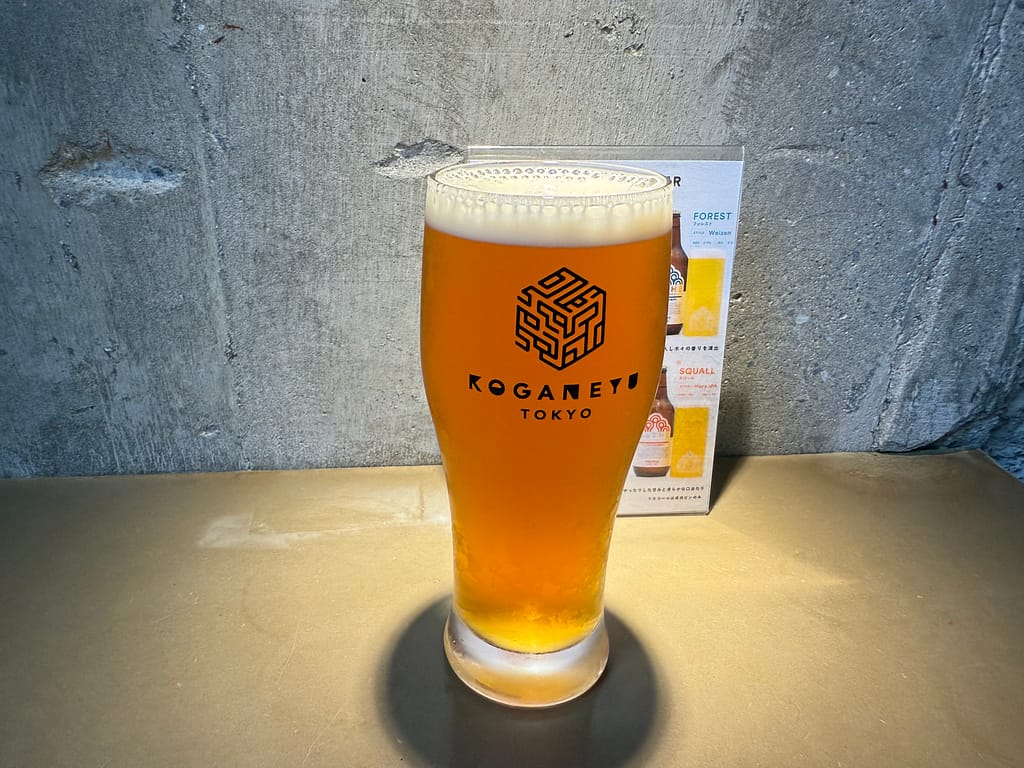 「サウナ施設・黄金湯のオリジナルクラフトビール。ロゴ入りグラスとビールメニュー」