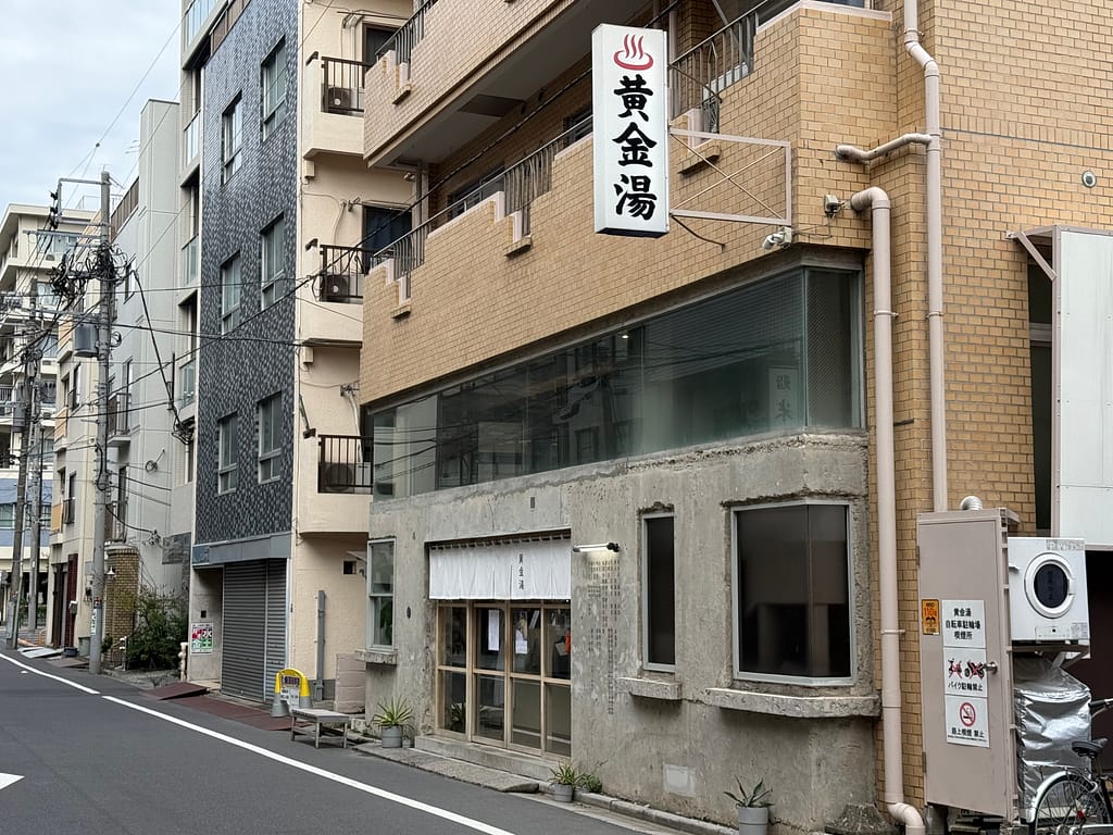 「錦糸町の人気銭湯サウナ『黄金湯』の外観。おしゃれなコンクリート調ファサードとレトロ看板が特徴」