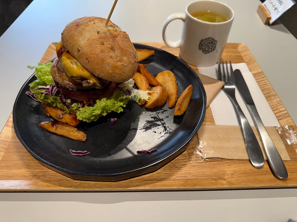 コガネキッチンのラムラムバーガー。ラム肉パティとチーズ、野菜を挟んだボリューム満点のハンバーガーとポテト