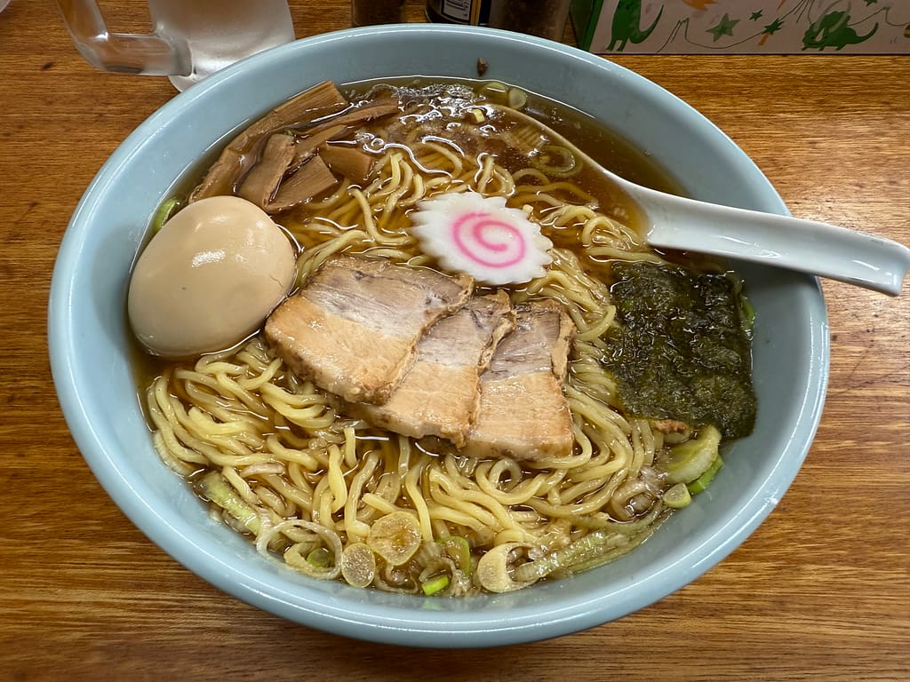 「船橋 温故知新の中華そば。醤油の香りが立つ澄んだスープに、縮れ麺、チャーシュー、味玉、メンマ、なると、海苔が盛られた一杯のラーメンの写真。」