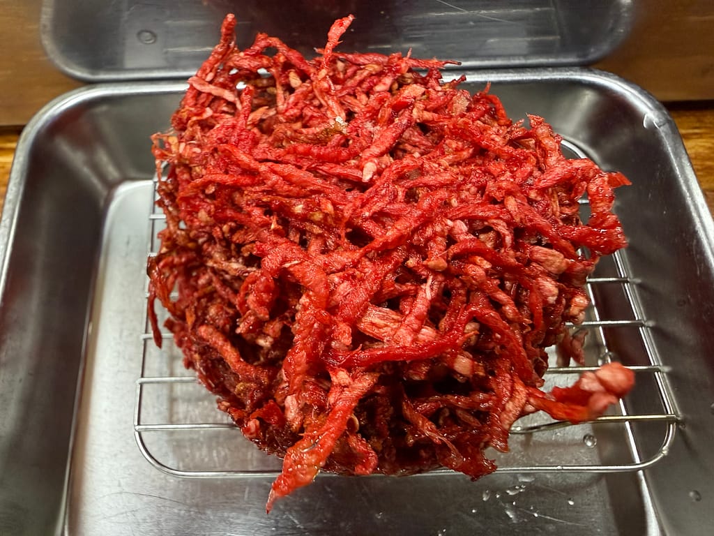 大衆酒場若林名物の紅生姜かき揚げ。真っ赤な紅生姜を大量に使用した巨大なかき揚げで、サクサク食感と強い酸味が特徴。