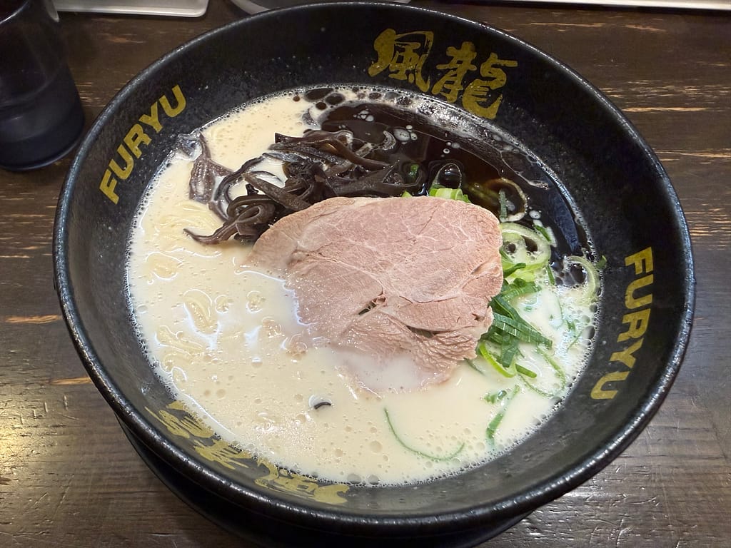 博多風龍 上野店の黒マー油とんこつラーメン。クリーミーな豚骨スープに極細麺、チャーシュー、きくらげ、青ねぎがのった一杯。