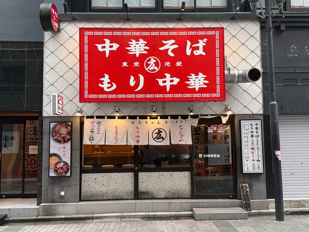 池袋駅近くの「ひろちゃんラーメン!」店舗外観。赤い看板と白い暖簾が特徴的な人気ラーメン店で、朝ラーメンも楽しめる話題の中華そば専門店。