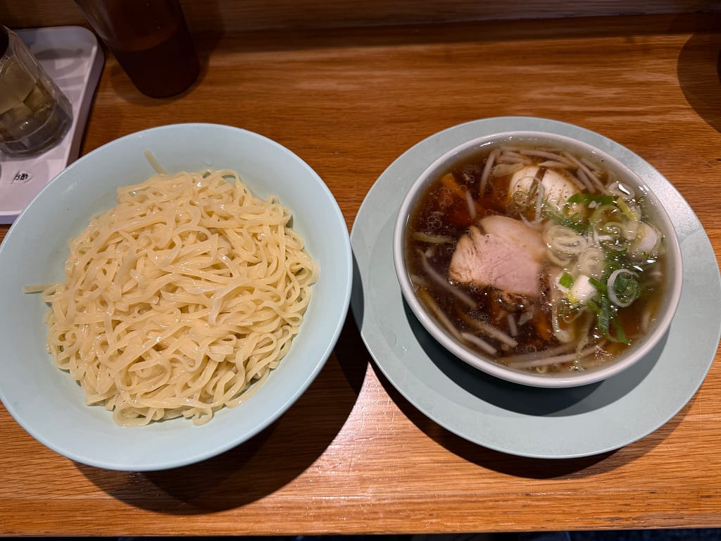 池袋ひろちゃんラーメン!のつけ麺。コシのある中太麺と、チャーシューやネギが入った醤油ベースのつけ汁を上から撮影。