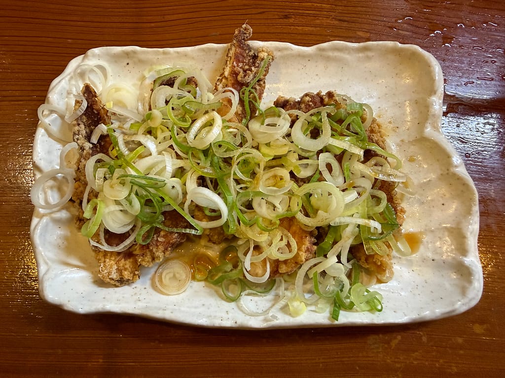 三代目らーめん処 まるは 極 ~KIWAMI~ 船橋店の油淋鶏。揚げたての鶏肉にたっぷりの
ねぎをのせ、甘酸っぱい特製ダレをかけた一品。