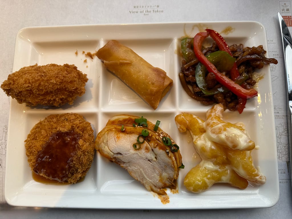 浅草ビューホテル スカイグリルブッフェ武藏の中華料理プレート。春巻きやチャーシュー、揚げ物などを盛り付けた一皿。