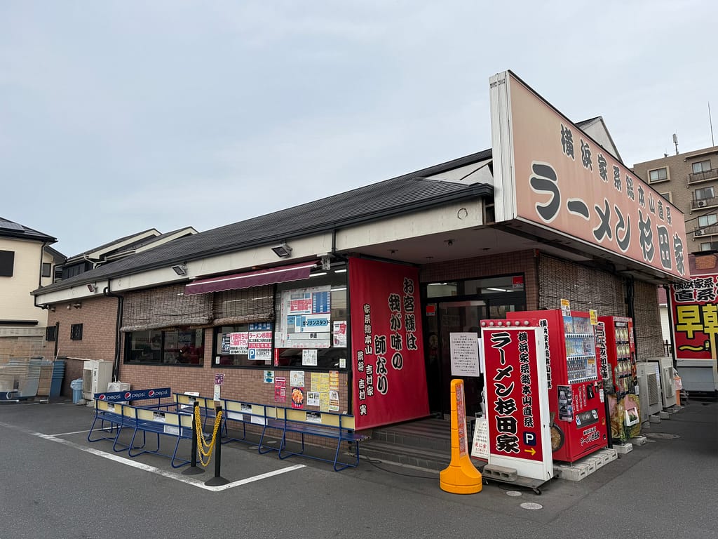 「杉田家 千葉祐光店の外観。横浜家系ラーメン直系の人気店で、入口前に行列用のベンチが並ぶ店舗」