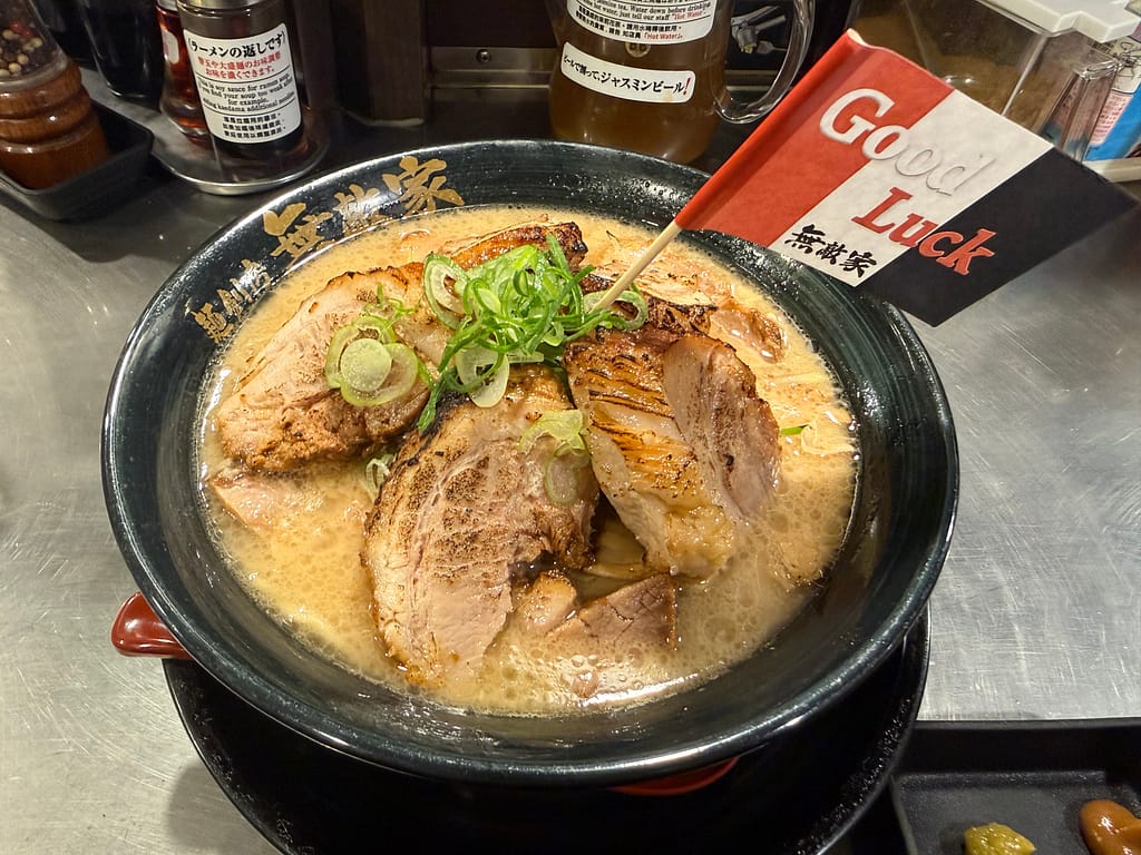 「麺創房 無敵家」の1ポンド・ドカ盛りちゃうしゅう麺普通盛。肉厚チャーシューが豪快に盛られ、「Good Luck 無敵家」の旗が刺さった迫力満点の一杯。