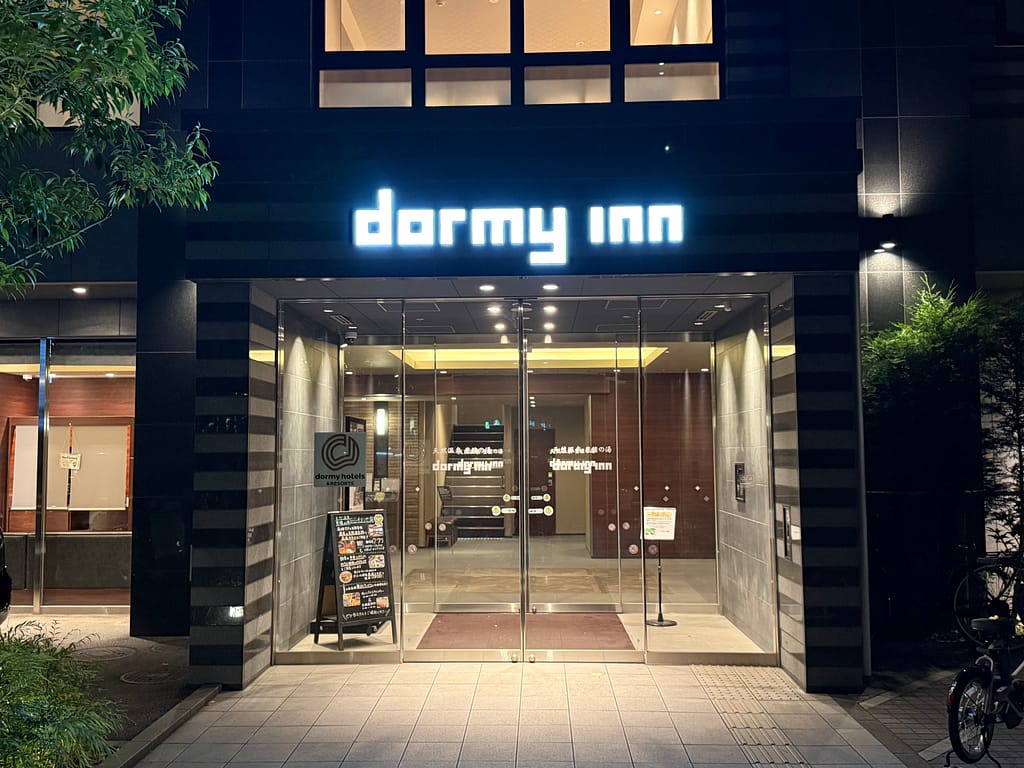 ドーミーイン池袋の夜の外観と入口|サウナ・天然温泉付きホテルのエントランス風景