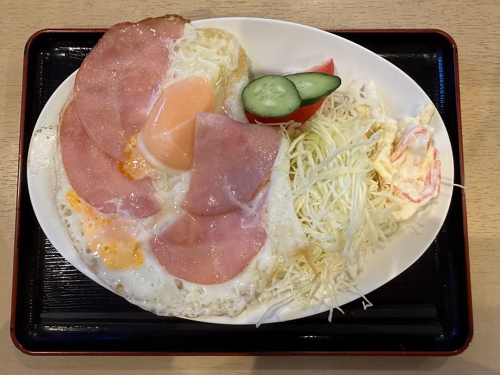 サウナセンター鶯谷本店のハムエッグ。半熟目玉焼きとハム、サラダが添えられた定番のサウナ飯。