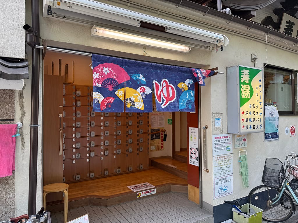 上野の銭湯「寿湯」の入口。暖簾や下駄箱が並び、昔ながらの雰囲気が感じられる。