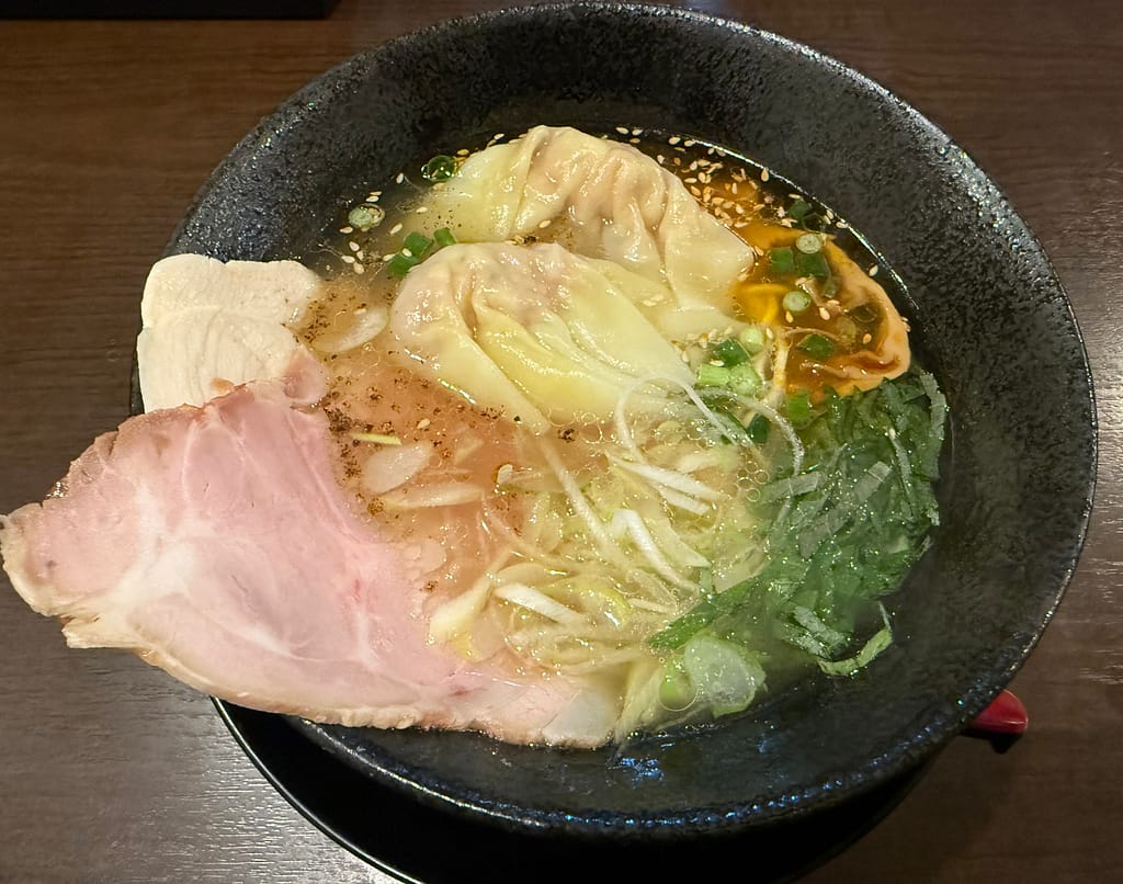 特製牛骨らぁめん。牛骨スープにチャーシューとワンタン、刻みネギをのせた一杯。