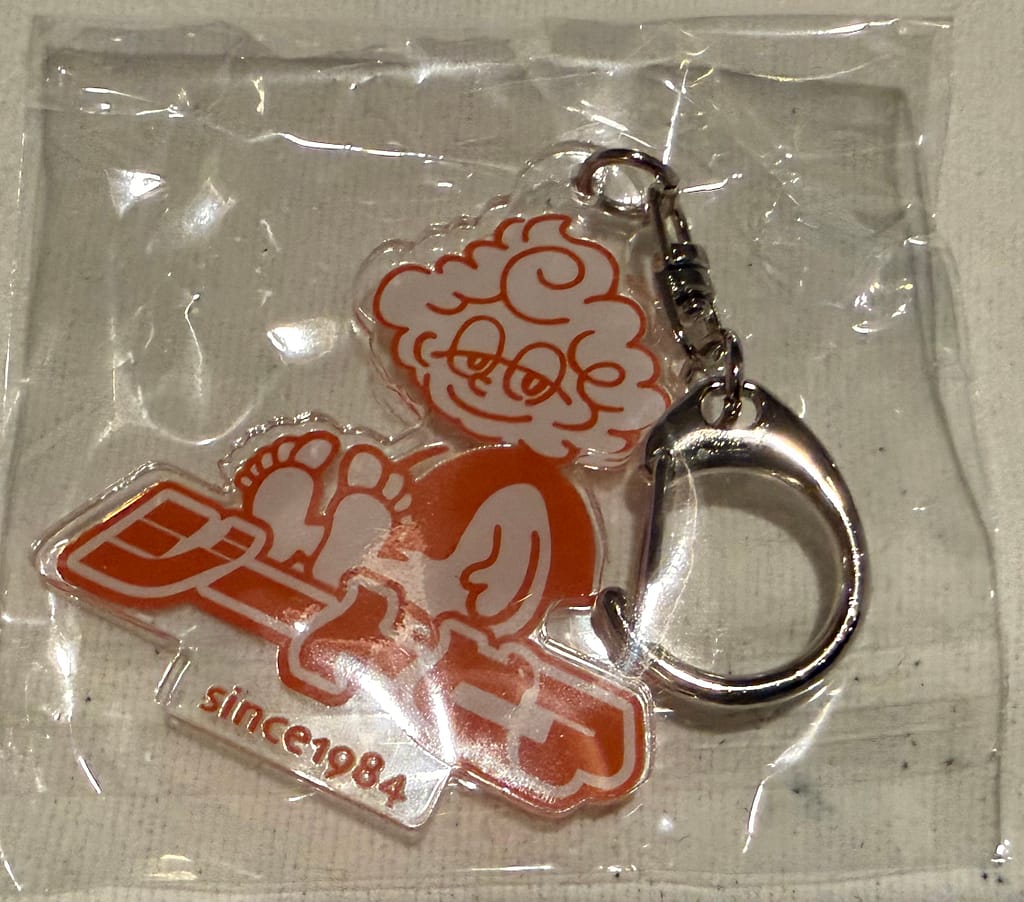 「サウナ北欧の公式キャラクターが描かれたアクリルキーホルダー。リクライニングチェアでくつろぐデザイン(since1984)」