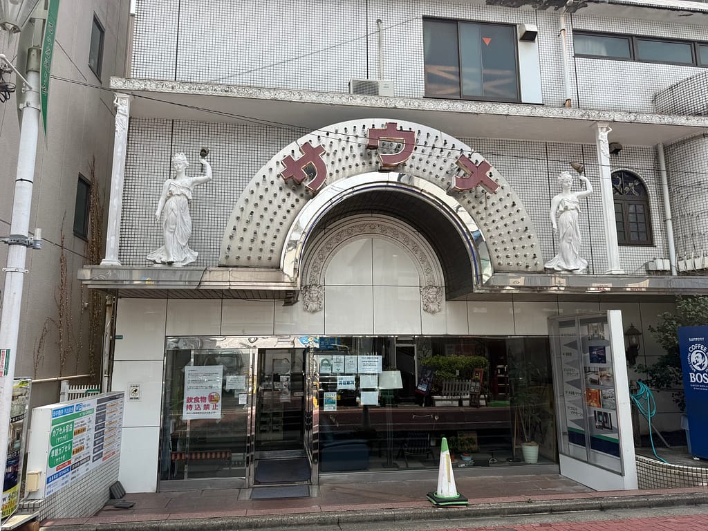サウナ&カプセルホテルニュー小岩310の店舗正面。アーチ状の「サウナ」看板と左右の装飾が特徴的な外観。